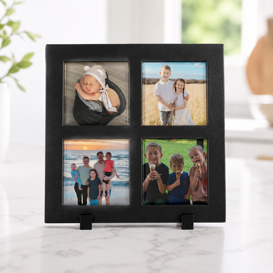 Black multi-picture frame with family photos on a marble surface