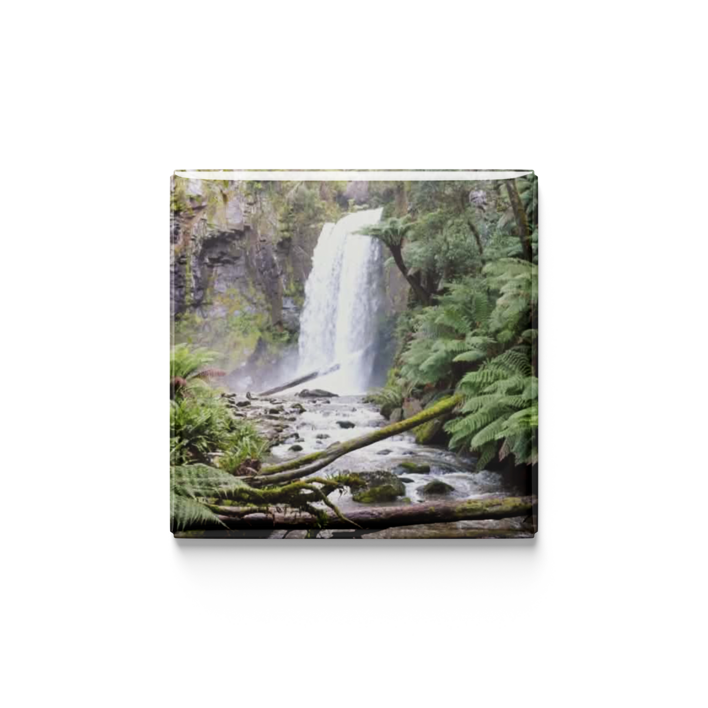 Magnet of a waterfall surrounded by greenery on a white background